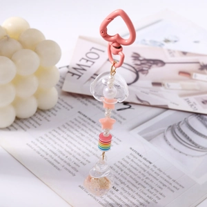 Pink heart-shaped keyring with jellyfish charm, faux pearls, and a mini glitter bottle