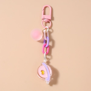 Détail du porte-clés rose avec breloque planète bonbon et pendentif coeur pour sac à main