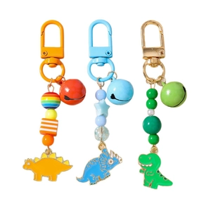 Three colorful beaded dinosaur keychains with bells in yellow, blue, and green colors