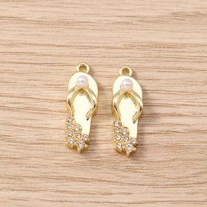 Detailansicht eines goldenen Flip-Flop-Anhängers mit Perle und Glitzersteinen