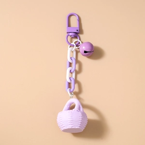 Détail du porte-clés violet avec chaîne épaisse, clochette et mini panier tressé