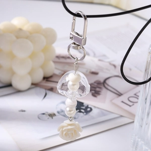 Détail d'un porte-clés méduse et rose blanche avec des perles élégantes et polies
