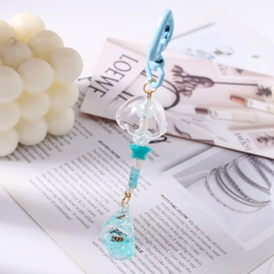 Detail of blue ocean style keychain featuring a beaded star and gradient glass conch pendant