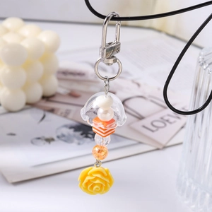 Détail du porte-clés méduse avec perles orange et pendentif en forme de rose jaune