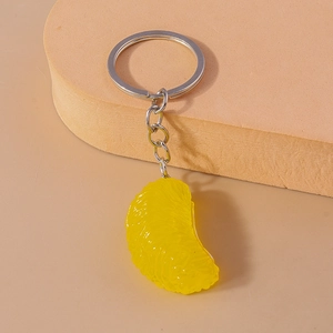 Dettaglio del portachiavi a spicchio d'arancia realistico con anello metallico argento