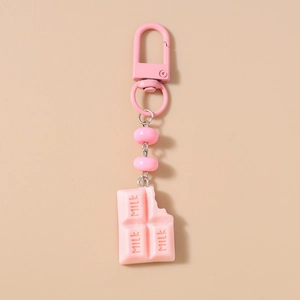 Detailed view of a pink milk chocolate keychain charm with a bite mark and metal clasp
