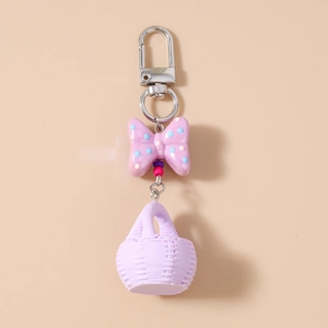 Detail of purple polka dot bow keychain with a miniature woven basket charm on a clean base