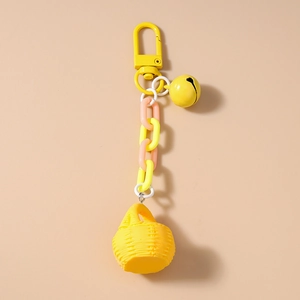 Détail d'un porte-clés jaune macaron avec un mini panier tressé et des breloques cloche