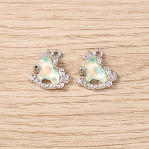 Detail of silver alloy unicorn rocking horse charms with iridescent resin inlay