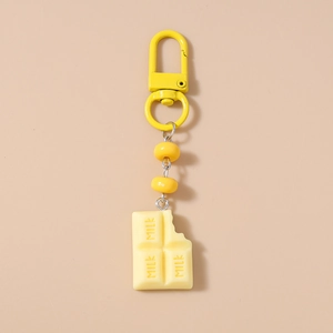 Detail of yellow milk chocolate keychain charm with beads and metal carabiner clip