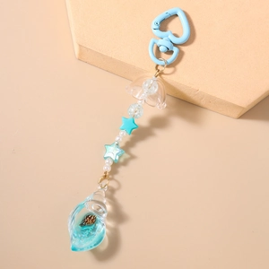 Detailed macro view of heart clasp, star beads and sea shell pendant with blue liquid