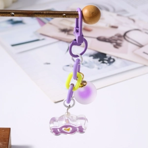 Détail du porte-clés papillon planète bonbon avec chaînes mauves et cœur acrylique