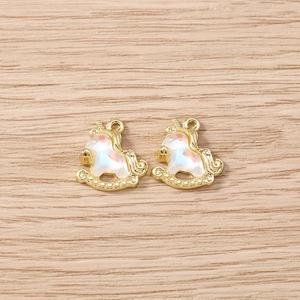 Close-up of golden unicorn rocking horse charms with iridescent enamel for DIY jewelry making