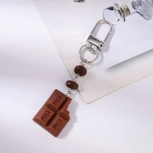 Detailed macro view of creative chocolate bar keychain with milk engraving and beads