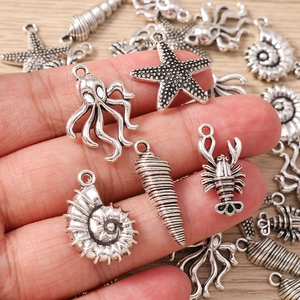 Dettaglio macro di ciondoli marini in argento vintage con stella marina e polpo per gioielli