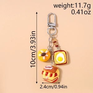 Detail view of bear bread keychain with fried egg toast and shop house charms