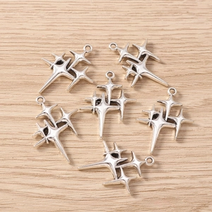 Macro shot of vintage silver four-pointed star cluster charms for DIY jewelry making