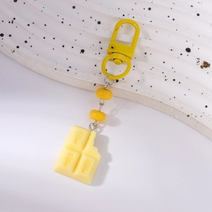 Detailed close-up of chocolate bar keychain with MILK lettering and yellow beads