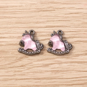 Macro detail of two pink unicorn rocking horse charms with gunmetal finish for DIY jewelry