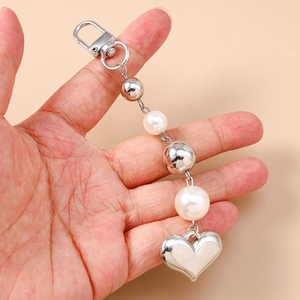 Porte-clés tendance en métal argenté avec perles blanches et pendentif en cœur