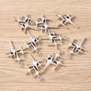 Macro shot of retro silver star pendants for DIY jewelry making on wooden background