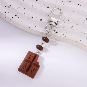 Detailed close-up of a brown chocolate keychain with milk text and bite marks