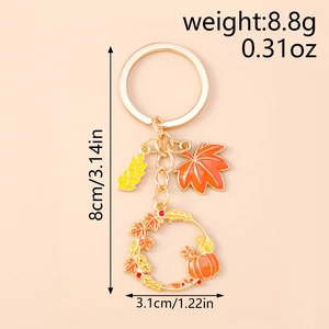 Detail showing autumn pumpkin wreath keychain with maple leaf and wheat charms, 8.8g weight