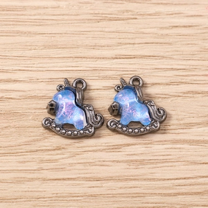Macro shot of unicorn charms with blue iridescent fill and gunmetal finish for DIY jewelry