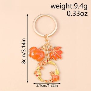 Detail view of pumpkin and maple leaf keychain with size dimensions in inches and grams