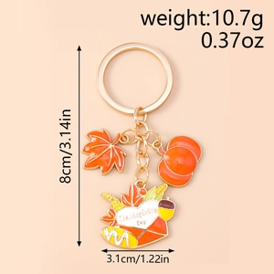 Detail of Thanksgiving keychain with gold enamel maple leaf, pumpkin, and heart envelope