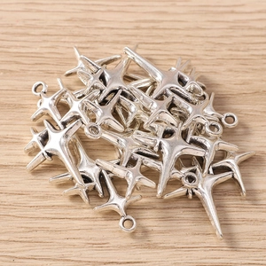 Macro shot of silver metal four-pointed star charms for DIY jewelry and bracelets