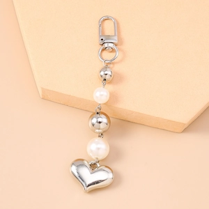 Porte-clés tendance avec pendentif cœur argenté et perles blanches sur socle chic