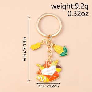 Detail view of Thanksgiving enamel keychain with corn, wheat, and envelope charms