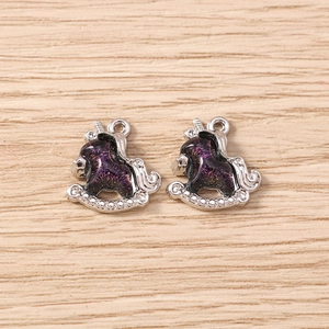 Detailed close-up of unicorn rocking horse charms with purple enamel for DIY jewelry