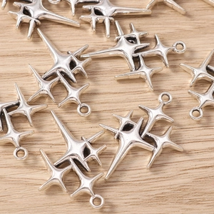 Detailed view of antique silver four-pointed star alloy pendants for DIY jewelry making