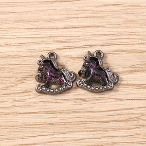 Detailed view of gunmetal unicorn pendants with purple and pink glitter enamel for jewelry