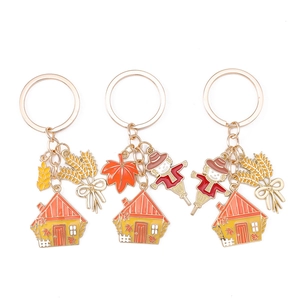 Three-piece autumn harvest keychain set with scarecrow, maple leaf and wheat pendants