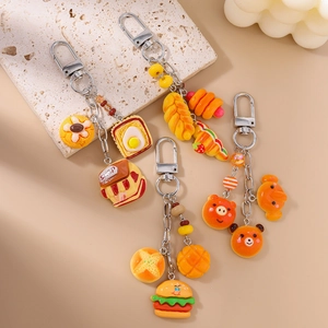 Flat lay of realistic resin bread keychains with burger and croissant on stone surface