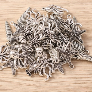 Dettaglio di ciondoli marini in argento antico come stelle marine e polpi per gioielli DIY