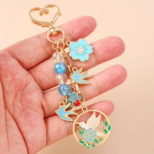 Porte-clés doré avec oiseaux en émail bleu et fleurs de pivoine sur crochet coeur