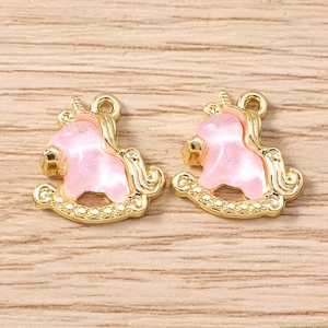 Detailed view of unicorn pendants with pink opal stones for DIY jewelry making