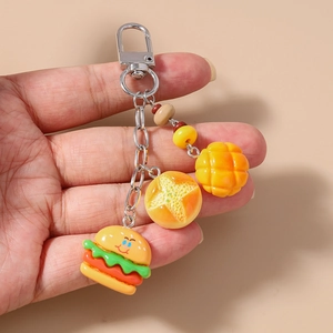 Detailed macro of adorable miniature burger and star-shaped bread charms on a keychain
