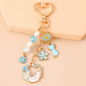 Détails du porte-clés doré chaton et fleurs avec perles bleu clair et breloques