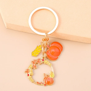 Detailed view of autumn pumpkin wreath keychain with maple leaves and wheat ear charms