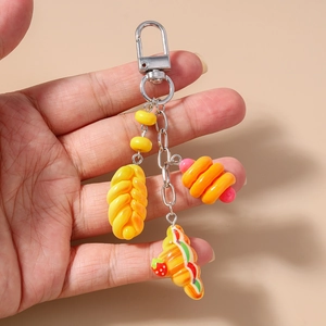 Close-up of realistic bear bread and croissant pendants on a silver metal keychain