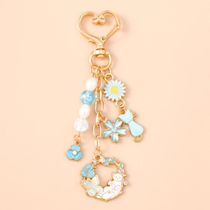 Détails d'un porte-clés pivoine bleue avec chat endormi et finitions dorées chic