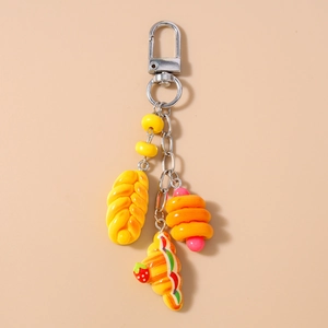 Detail of cute simulation bread keyrings with croissant and twist roll charms on D-ring