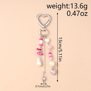 Detail of beaded keychain with pink heart pendant, teardrop pearl and shiny rhinestones