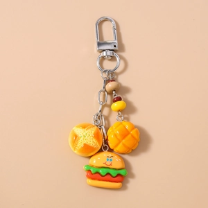 Detailed view of miniature resin food charms including bread and burger on a silver keychain