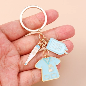 Close-up of nurse scrub and thermometer enamel charms on a gold medical keychain